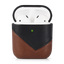 Two-tone brown and black leather AirPods case (TERRA), open showing white AirPods and green LED — FCC visible inside lid